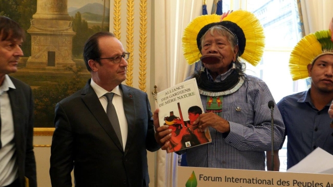 le Cacique Raoni remet le fruit du travail de l'Alliance des Gardiens de Mère Nature au président François Hollande